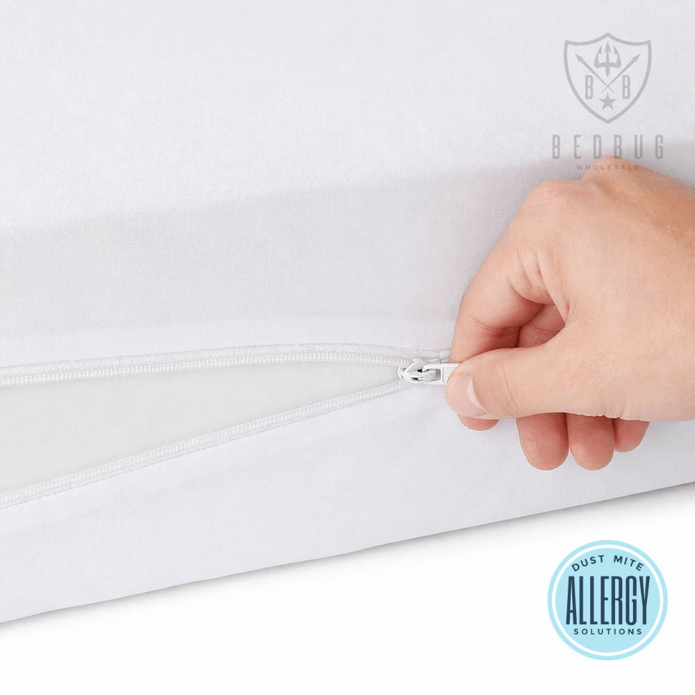 Hand zipping a white dust mite mattress cover with a brand logo and dust mite allergy solution label.