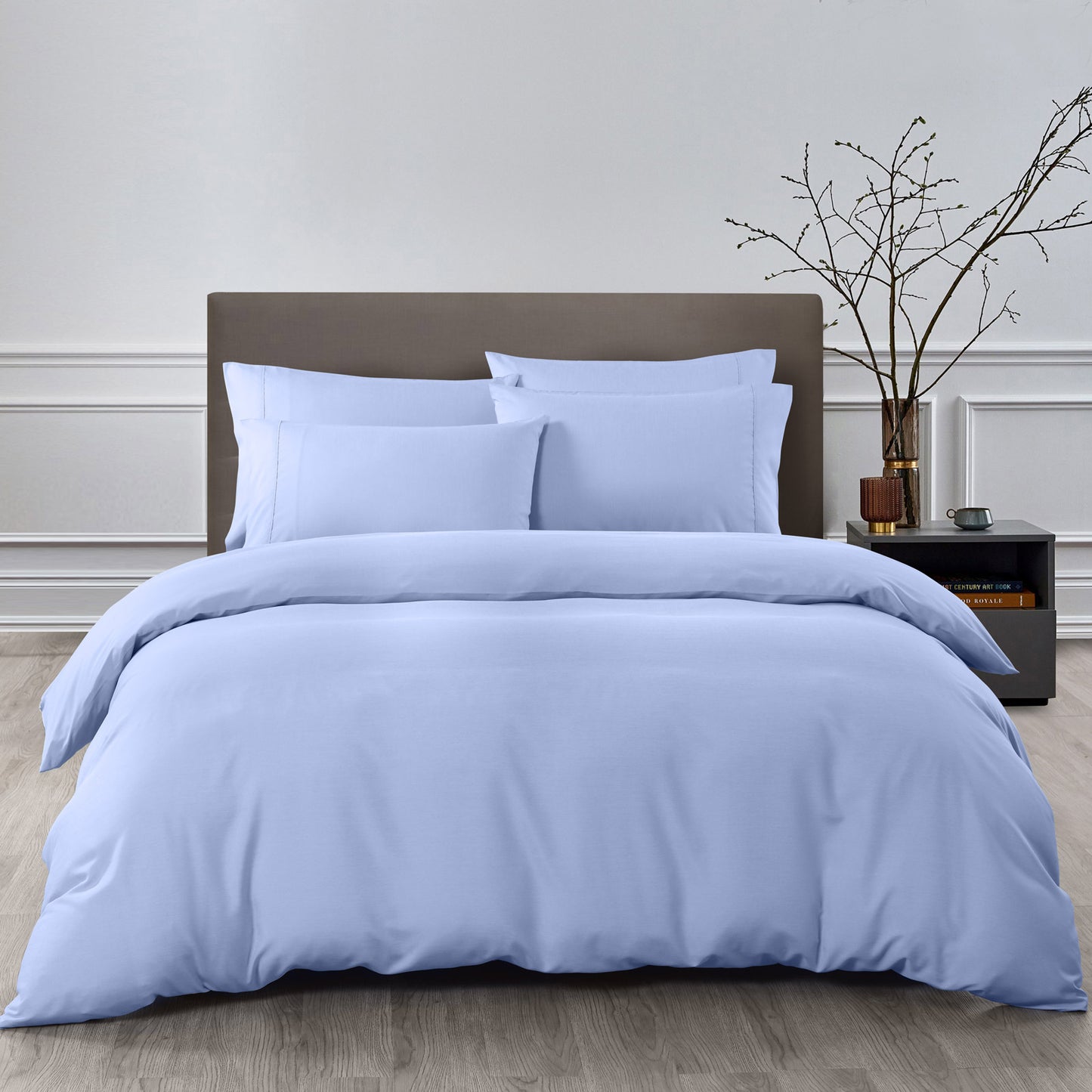 Blue bedding set on a bed with a wooden headboard and nightstand in a bedroom setting.
