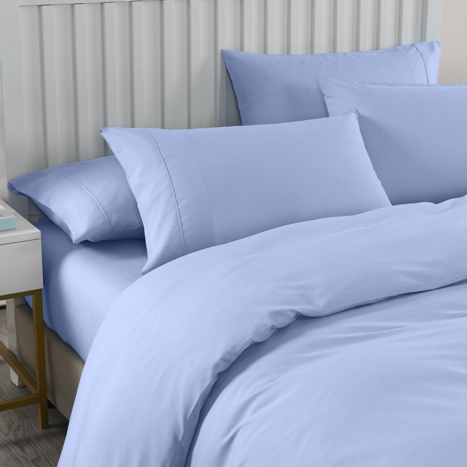 Blue bedding set on a bed with pillows and a duvet cover.