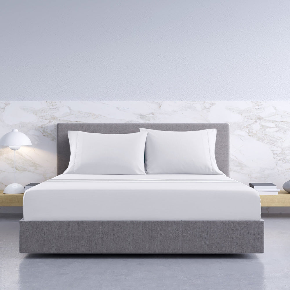 Modern bedroom with a gray bed and white pillows against a marble wall. Soft breathable bamboo cotton sheets white king size bedroom styling Dust Mite Allergy Solutions Australia