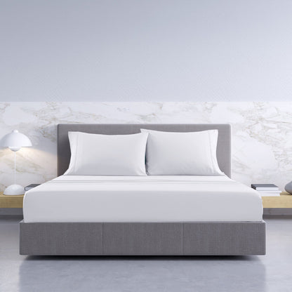 Modern bedroom with a gray bed and white pillows against a marble wall. Soft breathable bamboo cotton sheets white king size bedroom styling Dust Mite Allergy Solutions Australia