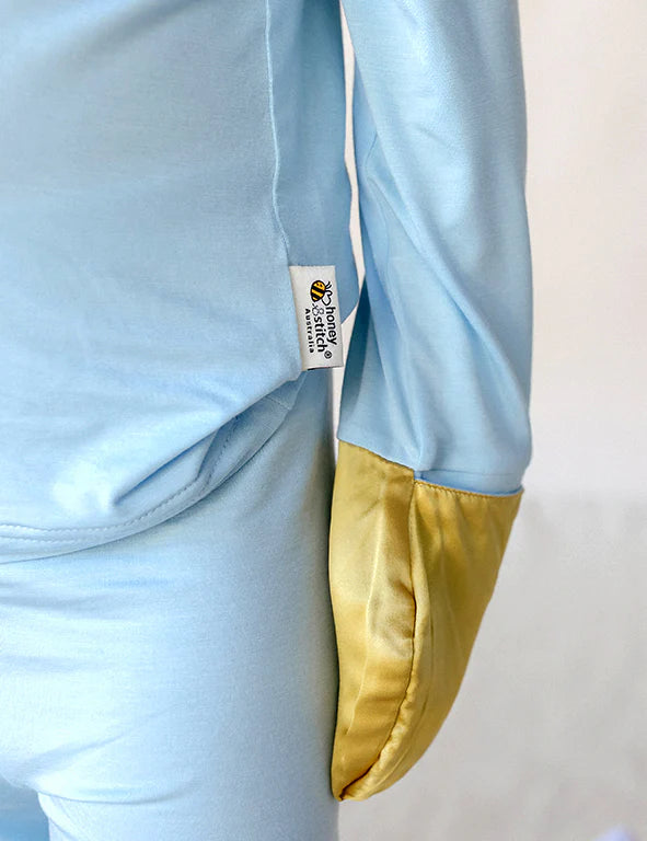 Close-up of the fold-over gold mulberry silk mitten on a blue organic bamboo pyjama top 