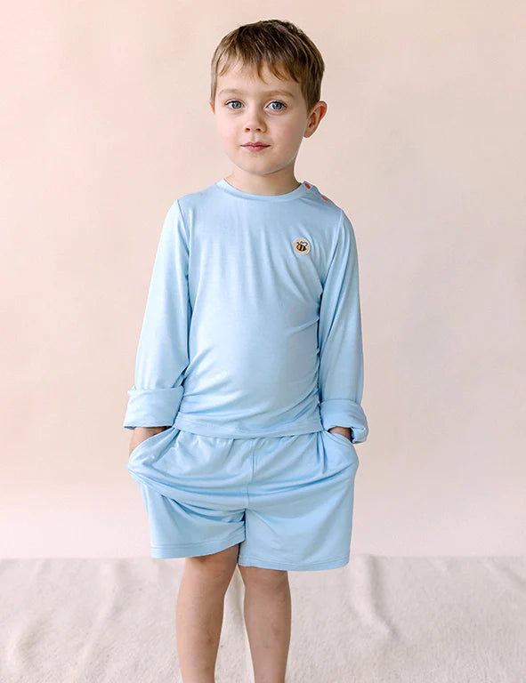 Boy with hands in the pockets of light blue organic bamboo kids' shorts — eczema-friendly by Honey & Stitch
