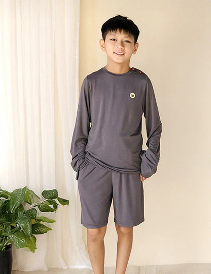 Boy wearing charcoal eczema-friendly organic bamboo shorts and long-sleeve top by Honey & Stitch